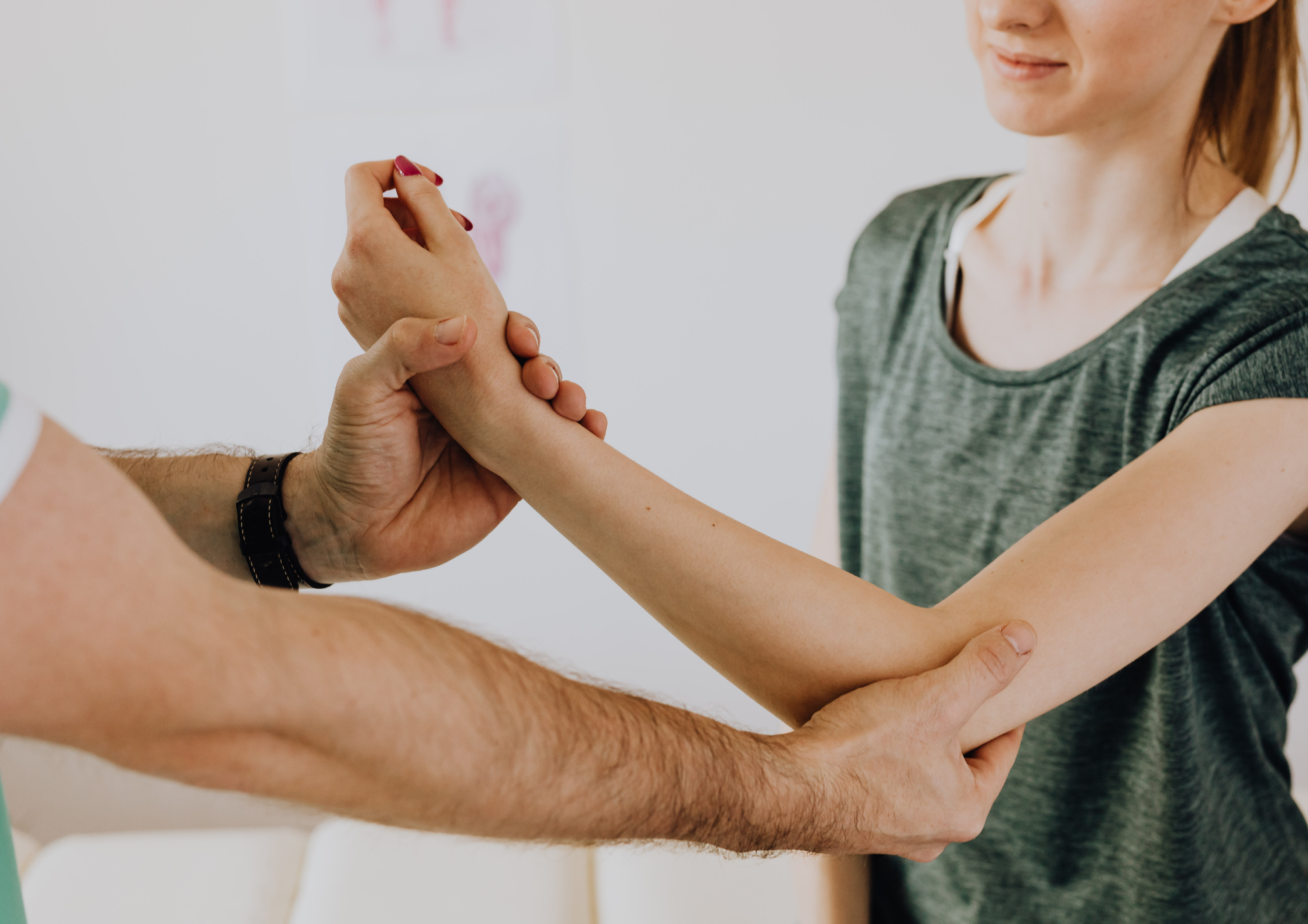 Therapeut untersucht den Arm einer Patientin in einer Praxis als Symbol für steuerliche Beratung von Heilberufen durch die Dr. Hollmann Steuerberatungsgesellschaft mbH.